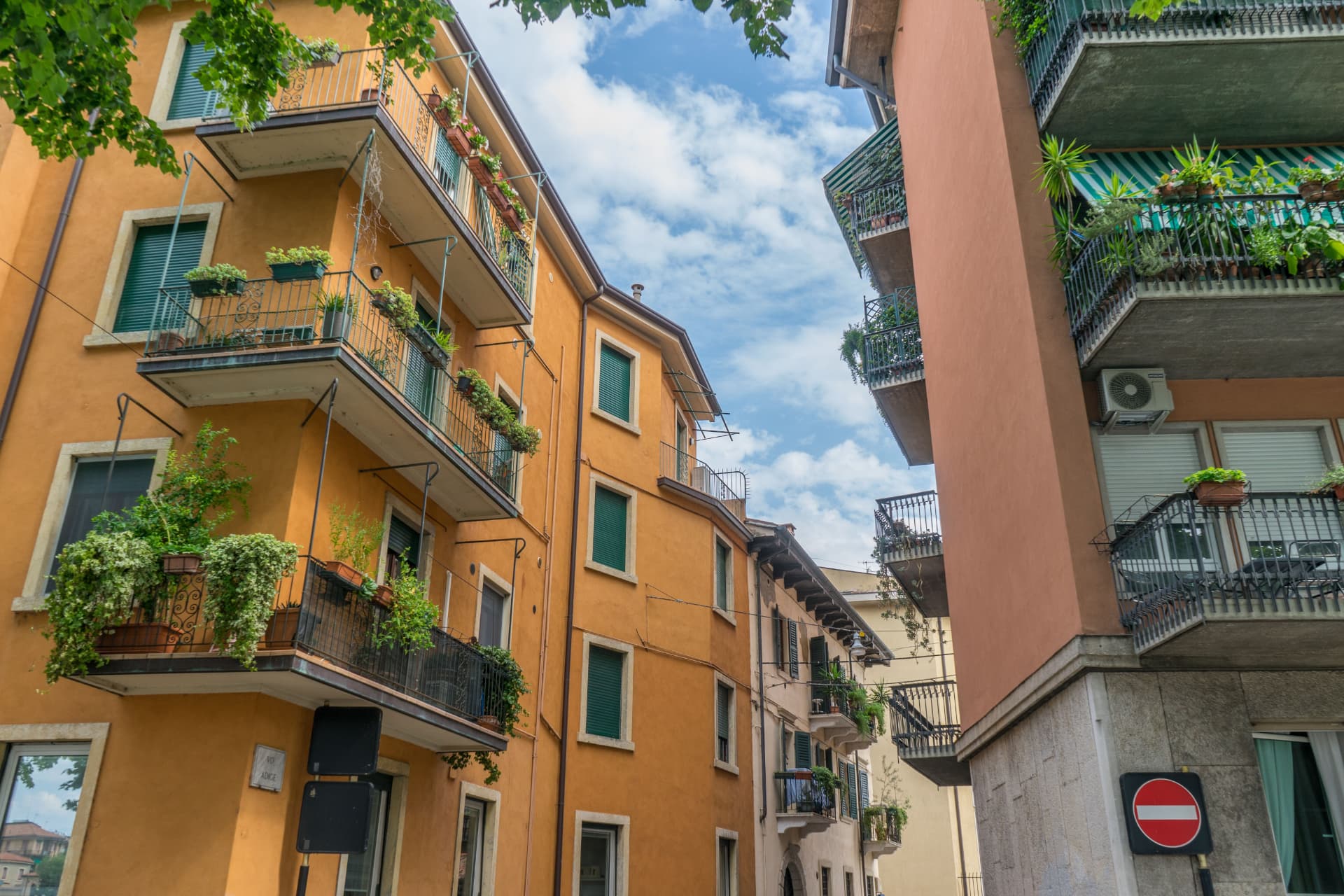 Palazzi residenziali con balconi e piante lungo una strada